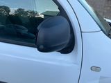 un camion blanc garé sur un parking à côté d'un bâtiment en briques