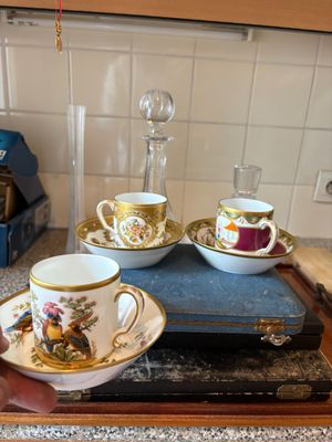 une personne tenant une tasse et une soucoupe sur un plateau