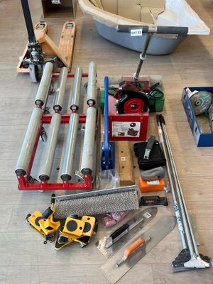 beaucoup d'outils par terre, à côté d'un bateau
