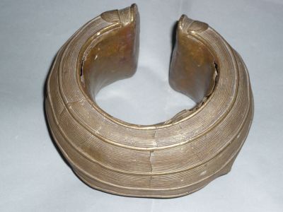 gros plan d'un bracelet en or sur une surface blanche