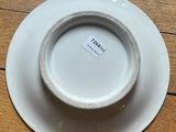 a close up of a white plate on a wooden table