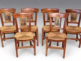 four wooden chairs with pictures on them sitting next to each other