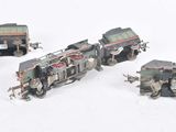 four miniature trains that are sitting on a white surface