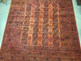 Il y a un vieux tapis par terre dans une pièce.