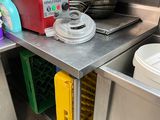 une petite cuisine équipée d'un évier et d'un plan de travail sur lequel se trouve un mixeur