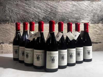 bottles of wine are lined up on a table in front of a stone wall