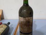 une bouteille de vin posée sur une table à côté de baguettes