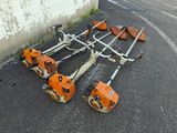 a group of lawn mowers laying on the ground next to a wall