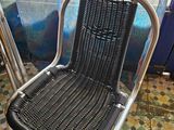 a black wicker chair sitting in front of a window
