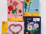 four cards with flowers and a heart are on a white surface