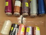 de nombreuses bobines de fil de différentes couleurs dans une boîte