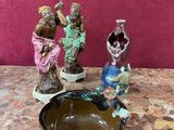 trois figurines posées sur une table, à côté d'un bol