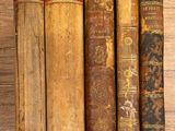 plusieurs vieux livres sont alignés sur une table en bois