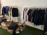a lot of clothes hanging on a rack in a room
