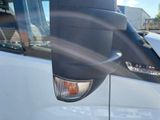 a side view mirror of a truck with a reflection of a person in the mirror