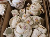 a box full of teapots and cups on the floor