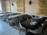 Il y a de nombreuses tables et chaises dans ce restaurant aux murs blancs et jaunes.