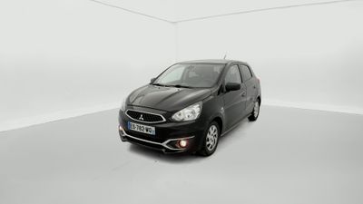 a black car is parked in a white room with a white wall