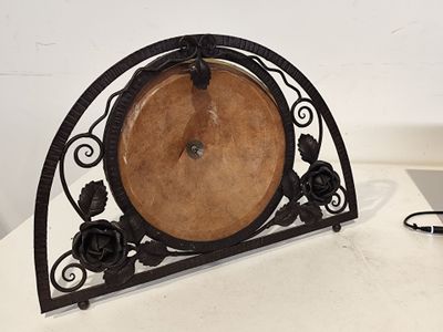 une horloge posée sur une table à côté d'un téléphone portable