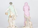 pair of porcelain figurines of a woman and a man with a dog