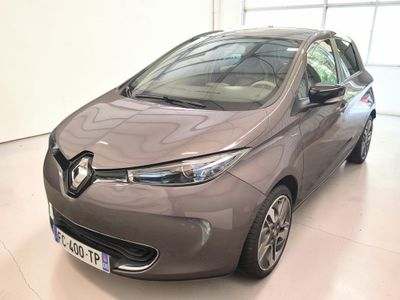 La voiture grise est garée dans une grande pièce dotée de nombreuses fenêtres.