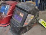 deux casques de soudage posés l'un à côté de l'autre sur une table