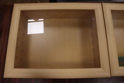 two wooden cabinets with glass doors on top of a table