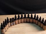 bottles of essential oils lined up on a wooden table with a black background