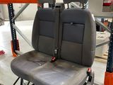 two seats in the back of a vehicle in a warehouse