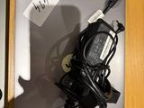 un ordinateur portable posé sur un bureau, avec un chargeur branché dessus