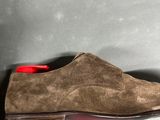 a close up of a pair of brown sued shoes on a gray surface