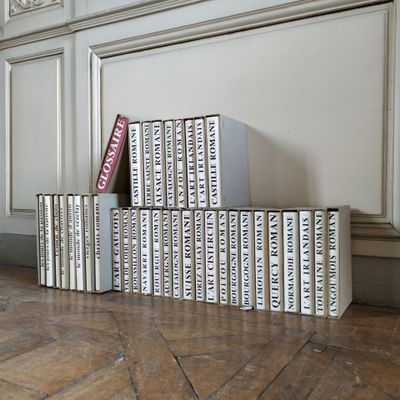 many books stacked on top of each other on the floor