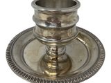 an antique silver plate with a candle holder on a white background