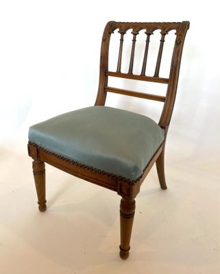 une chaise en bois avec une assise bleue posée sur un sol blanc