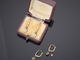 Deux paires de boucles d'oreilles sont posées dans une boîte violette sur une table.
