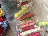 many spools of thread in a bag on a table