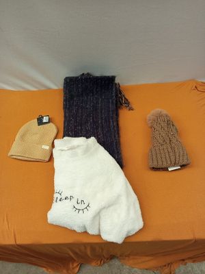 une couverture, un bonnet, une écharpe et des mitaines posés sur un lit