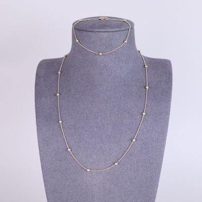 un collier en or orné de perles autour du cou d'un mannequin