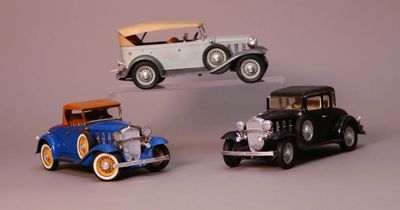 three toy cars sitting next to each other on a table