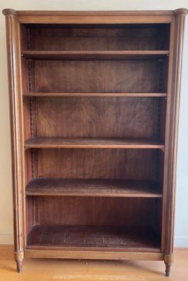 une photo d'une bibliothèque en bois dans un coin d'une pièce