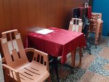 tables and chairs in a restaurant with red table cloths on them