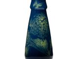 un vase bleu orné d'une fleur verte