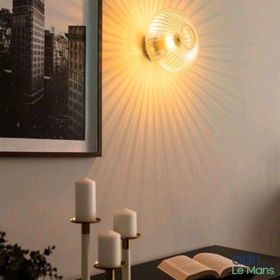 une lampe accrochée au mur à côté d'un livre