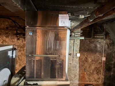 un petit réfrigérateur dans une chambre sale au sol sale