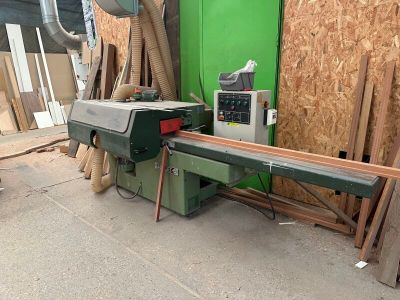 a machine that is cutting a piece of wood on a table