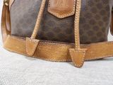 a close up of a brown and tan handbag on a white surface