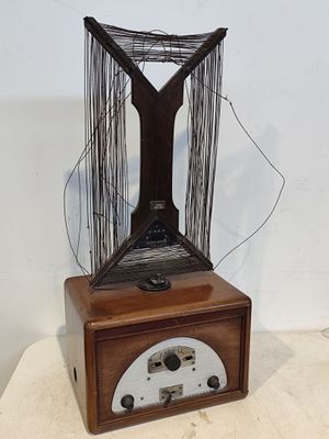une boîte en bois surmontée d'une sculpture en fil de fer