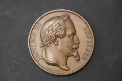 l'image d'une médaille d'or sur laquelle figure le visage d'un homme