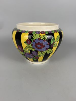 an image of a black and yellow bowl with grapes on it