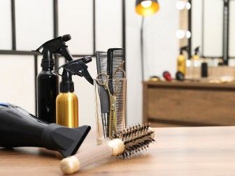 un sèche-cheveux, un peigne et un flacon de shampoing posés sur une table